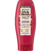 Flacon Garnier Whole Blends Color Care Conditioner avec huile d’argan et canneberge, hydratation et couleur protégée.