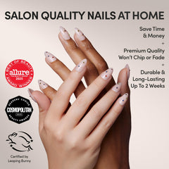 Close-up of short almond North Star nails showing raised gold foil and gems
