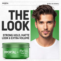 Immortal NYC, mains appliquant la cire coiffante pour texture naturelle.