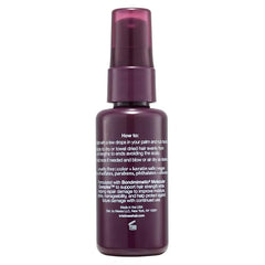 Mains appliquant le sérum Kristin Ess Peptide Restore pour nourrir les longueurs.