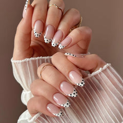 Ongles Mivota Almond Medium à poser, nude rose avec pois noirs et blancs.