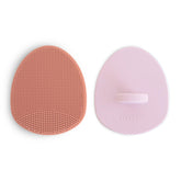 Brosse Mushie bébé en silicone rose, massage doux et élimination des croûtes.