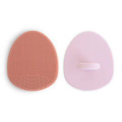 Brosse Mushie bébé en silicone rose, massage doux et élimination des croûtes.