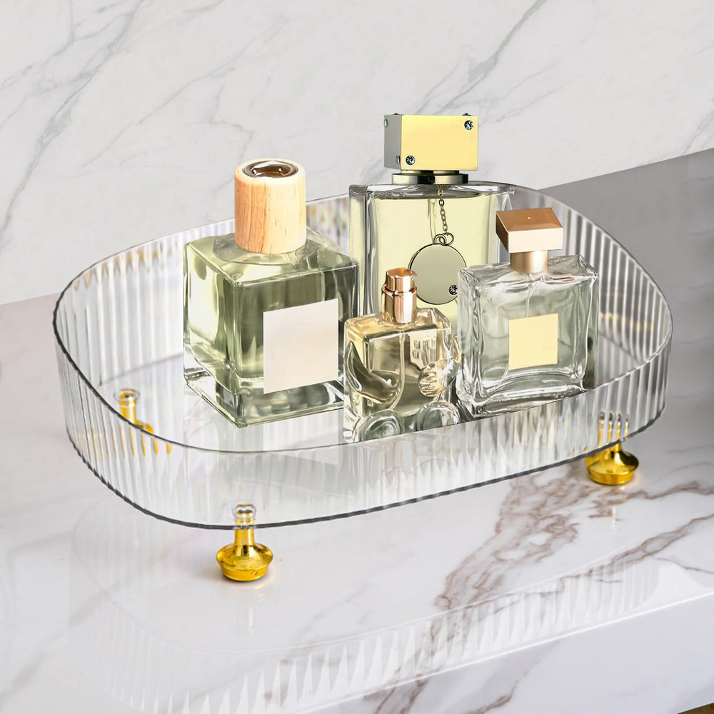 Neotidy organise les parfums sur un plateau transparent avec pieds dorés pour une présentation élégante.