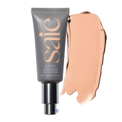 Saie Slip Tint dans sa bouteille en verre pour un teint lumineux.