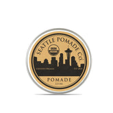 Seattle Pomade Co. pomade bio en pot révélant la cire d'abeille naturelle.