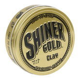 Shiner Gold Pommade Argile, bouteille visible montrant le maintien fort.
