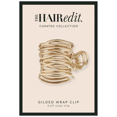The Hair Edit pince-cuff doré enveloppant la queue de cheval, maintien sans effort.