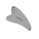 Tweezerman Gua Sha en acier inoxydable pour un massage visage apaisant et contours bien définis.