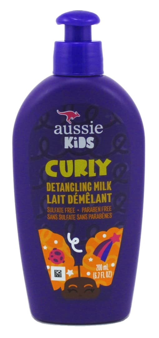 Aussie Kids Curly Detangling Milk, bouteille dans la main, démêlage doux pour cheveux bouclés.
