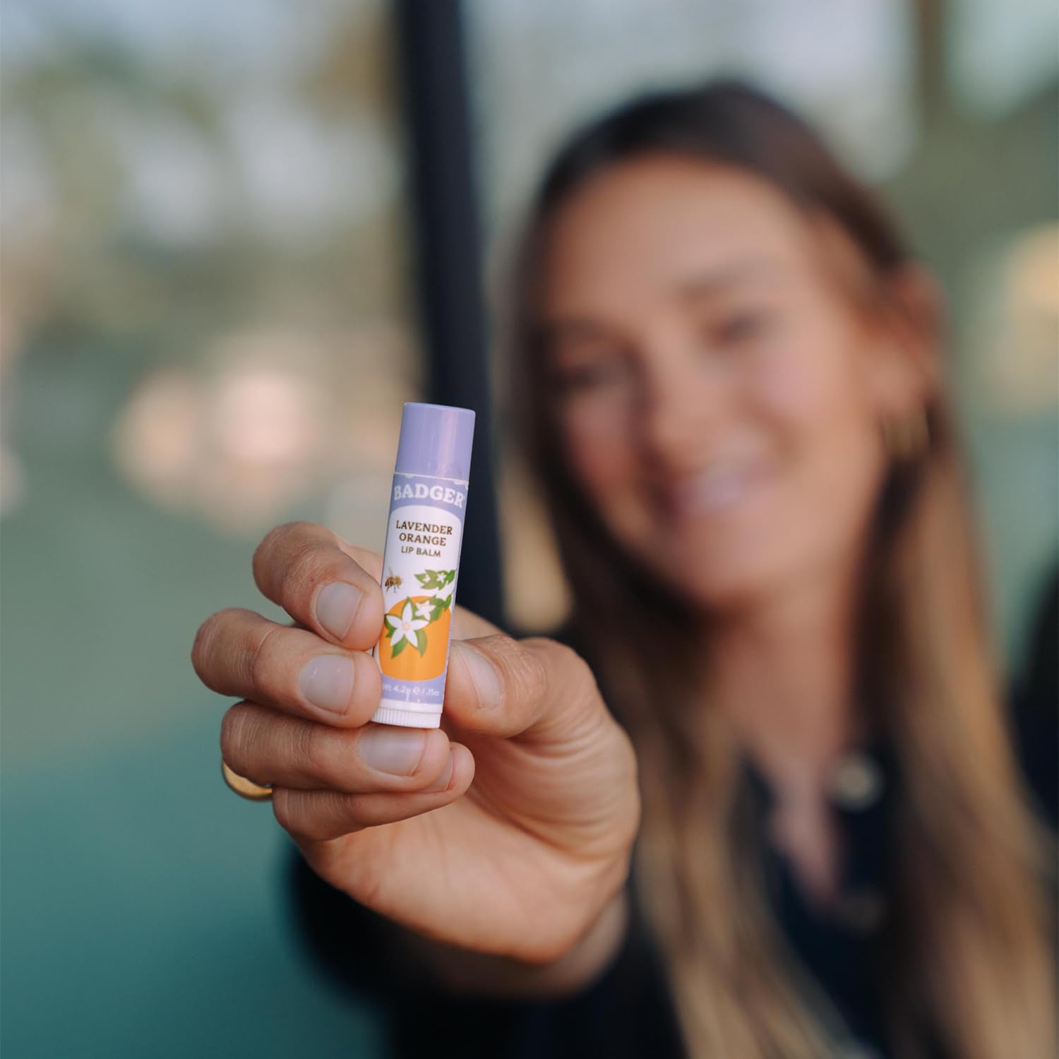 Badger Lavender Orange lip balm on lips with subtle shine.
