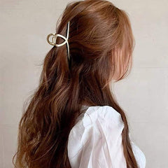Brinie pince-cheveux dorée, design géométrique ajoute une touche d'élégance.