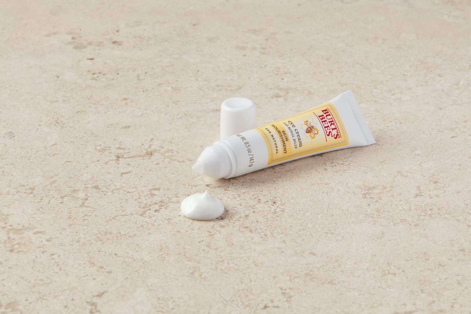 Application sous les yeux Burt's Bees dans un tube pratique.
