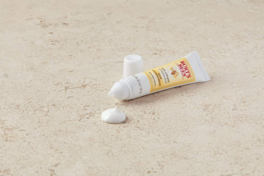 Application sous les yeux Burt's Bees dans un tube pratique.