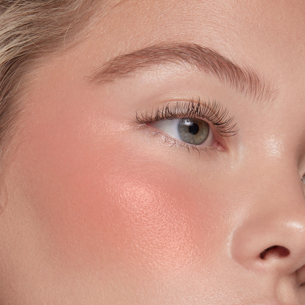 Application sur les joues avec ColourPop Weightless Liquid Blush pour un flush frais.
