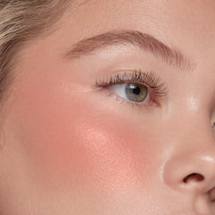Application sur les joues avec ColourPop Weightless Liquid Blush pour un flush frais.