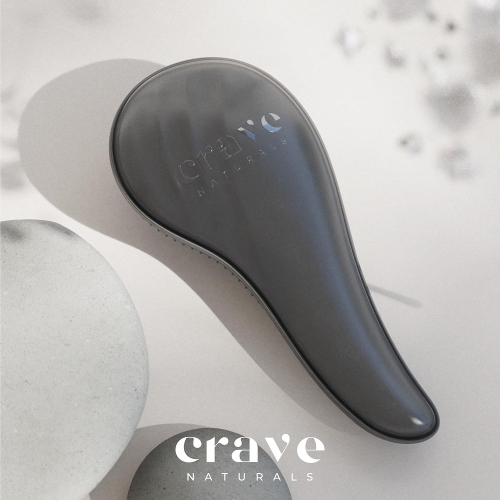 Crave Naturals brosse démêlante grande noire utilisée sur cheveux mouillés pour glissement fluide.