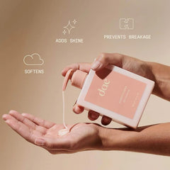 Main appliquant le produit sur les longueurs.