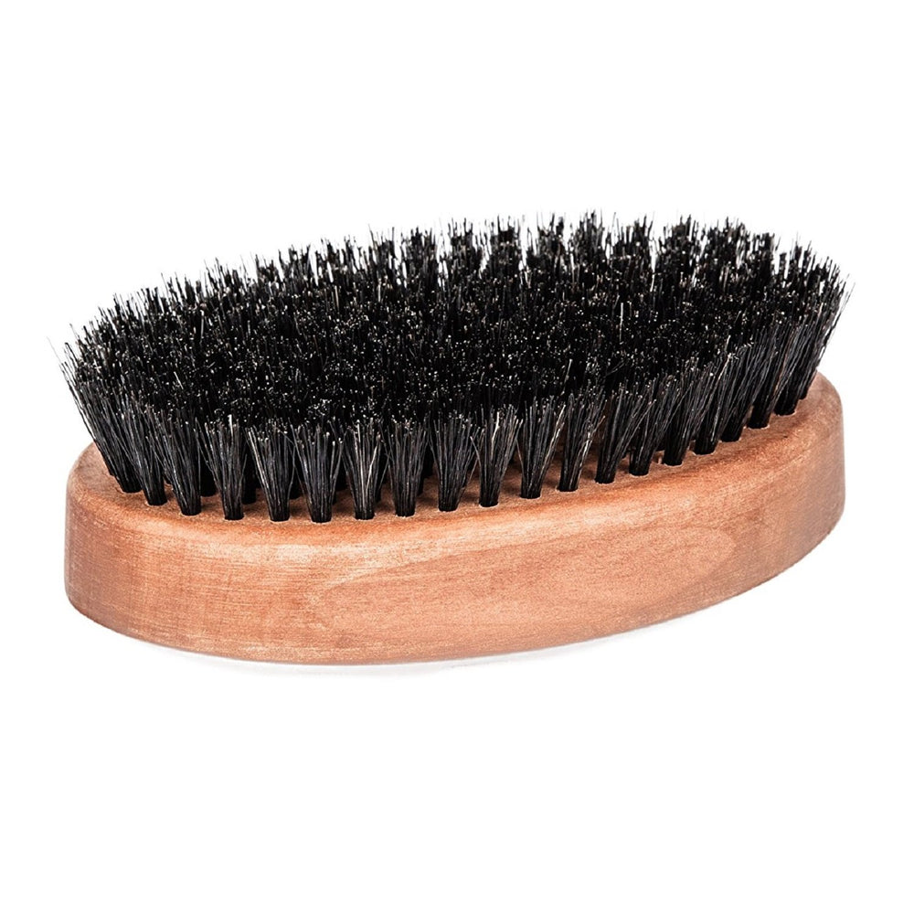 Main tenant la brosse Fendrihan avec un manche ergonomique en bois.