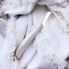 Outil non vibrant Finishing Touch Flawless Dermaplane Glo précision contrôlée sur le visage.