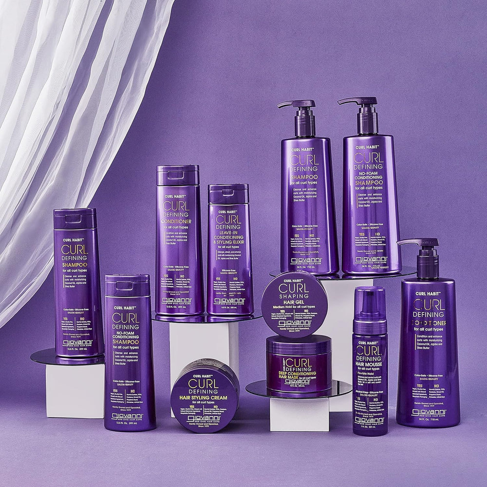 Mains appliquant l’après-shampoing sur cheveux mouillés pour styliser les boucles.