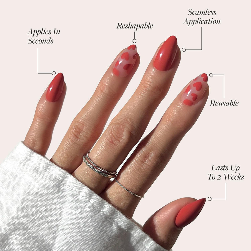 Glamnetic Love Me short almond shape nails with heart accents.