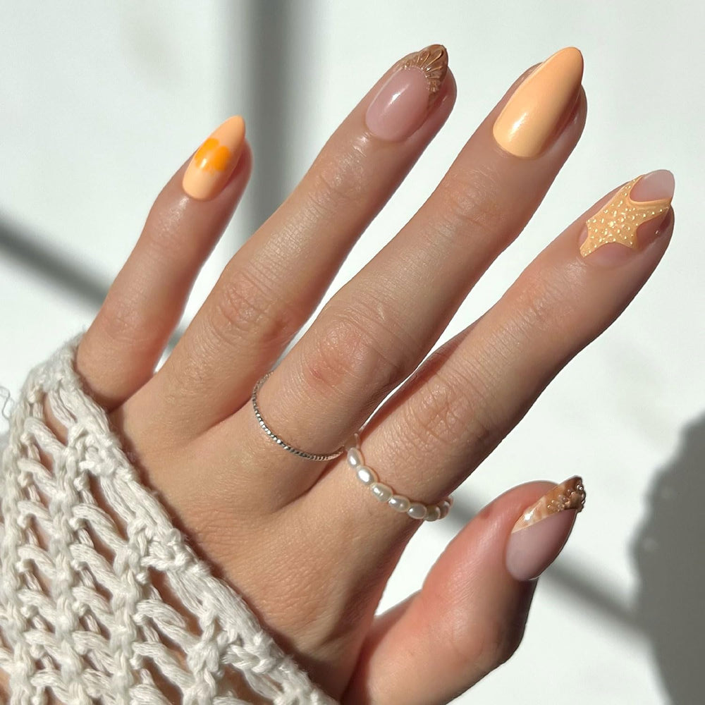 Glamnetic Sunny Shores press-on nails with orange shade and 3D starfish for beach-inspired look.