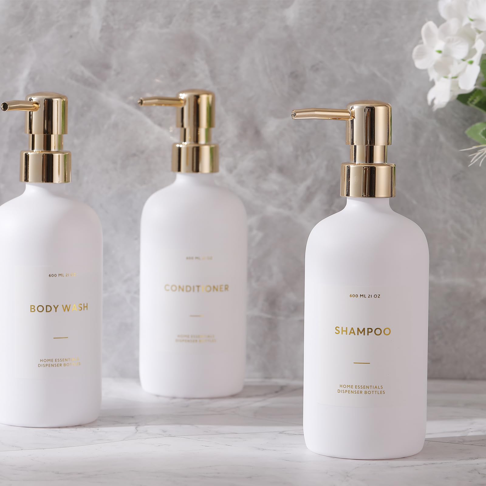 Bouteilles HOMCDALY alignées sur étagère, salle de bain moderne.