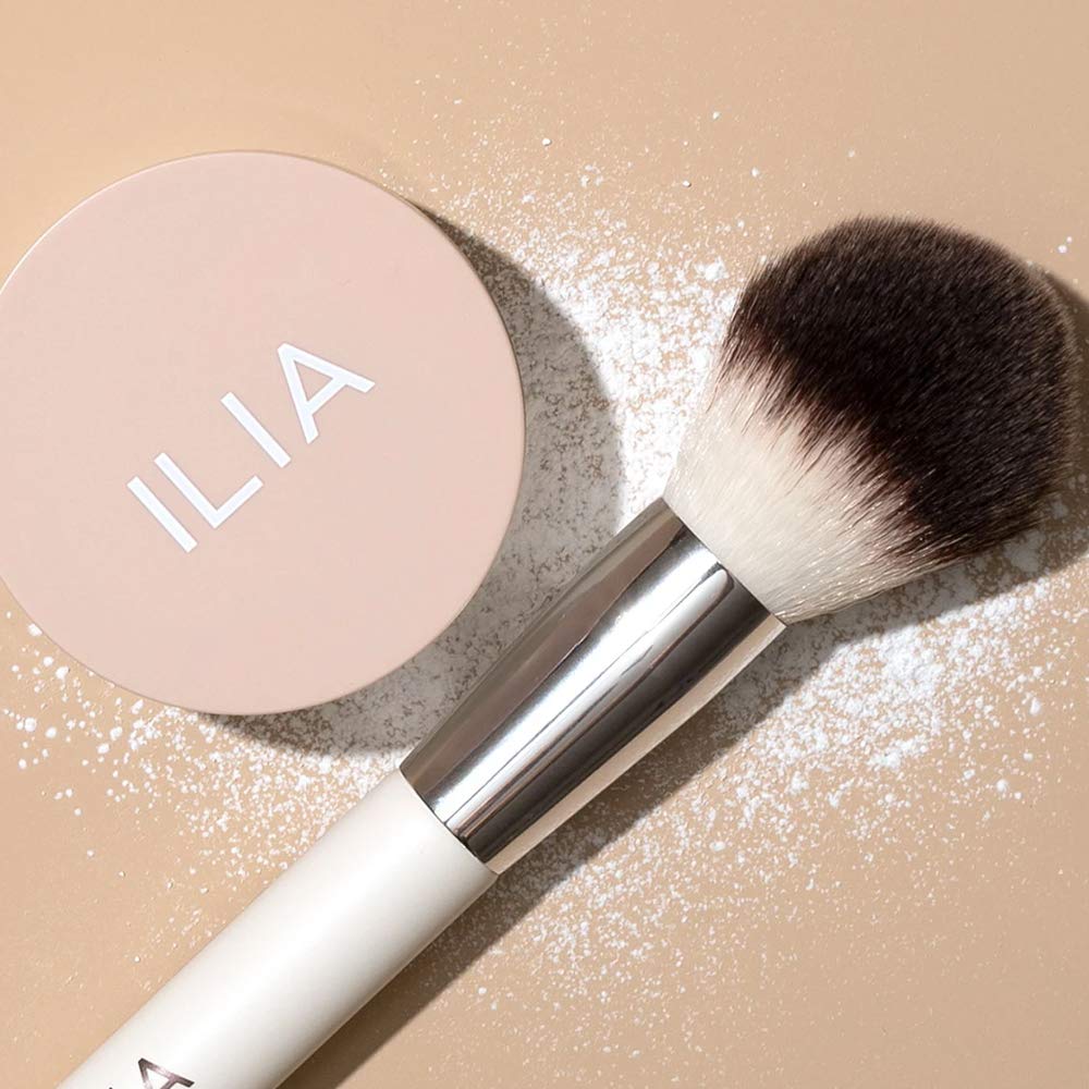 Application de la poudre ILIA avec pinceau pour une touche légère.