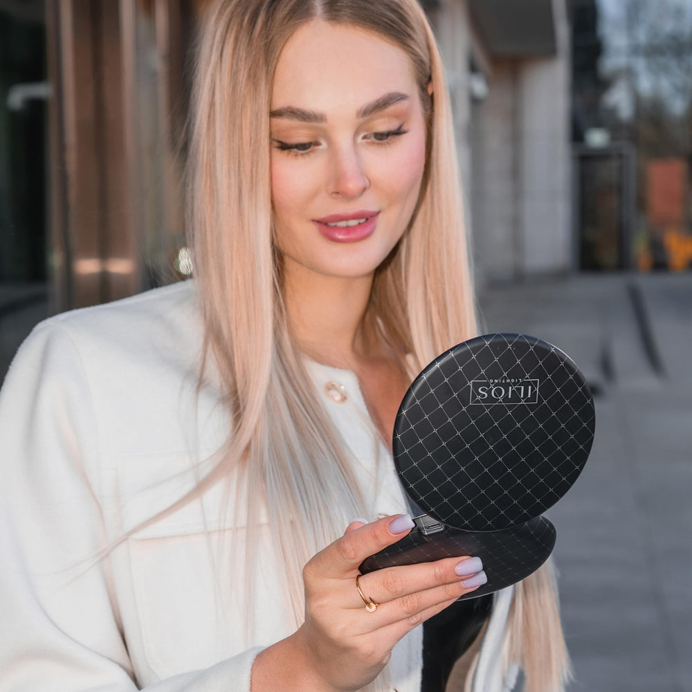 Miroir Ilios Lighting noir avec grossissements 1x et 10x pour maquillage précis.