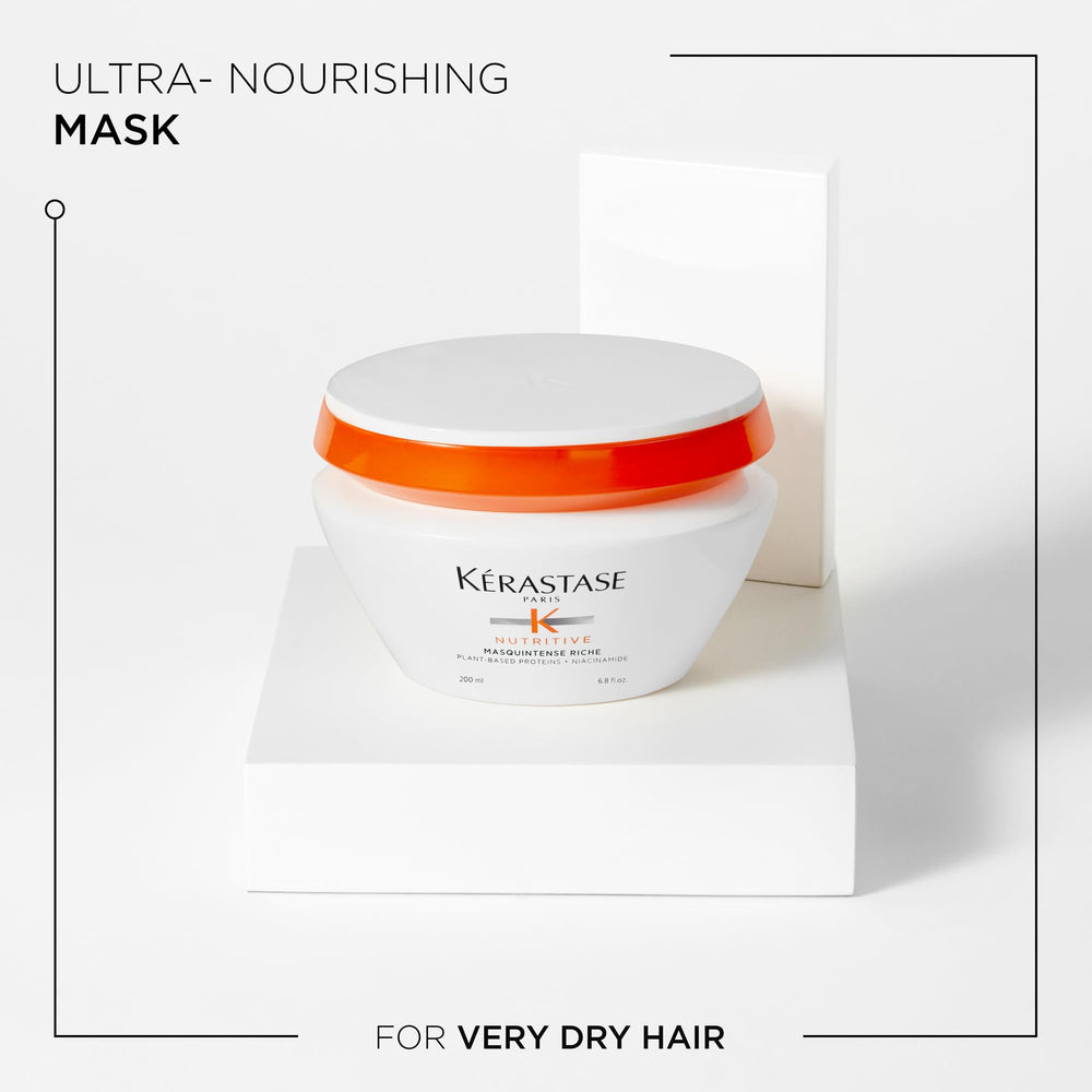 Main appliquant le masque Nutritive Masquintense Riche sur cheveux propres.