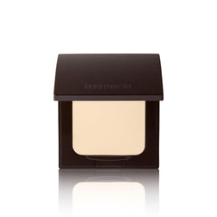 Laura Mercier poudre pressée translucide sur compact avec applicateur inclus, retouches faciles tout au long de la journée.