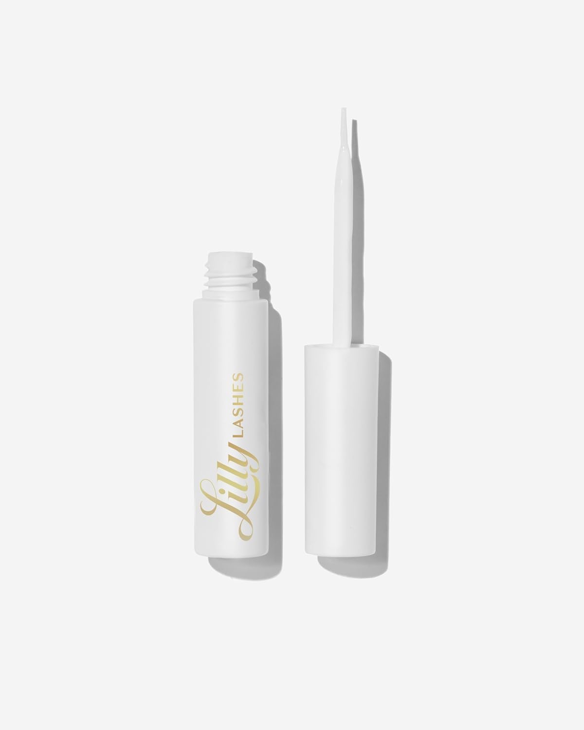 Lilly Lashes clear glue bottle with brush-on applicator for precise lash placement.