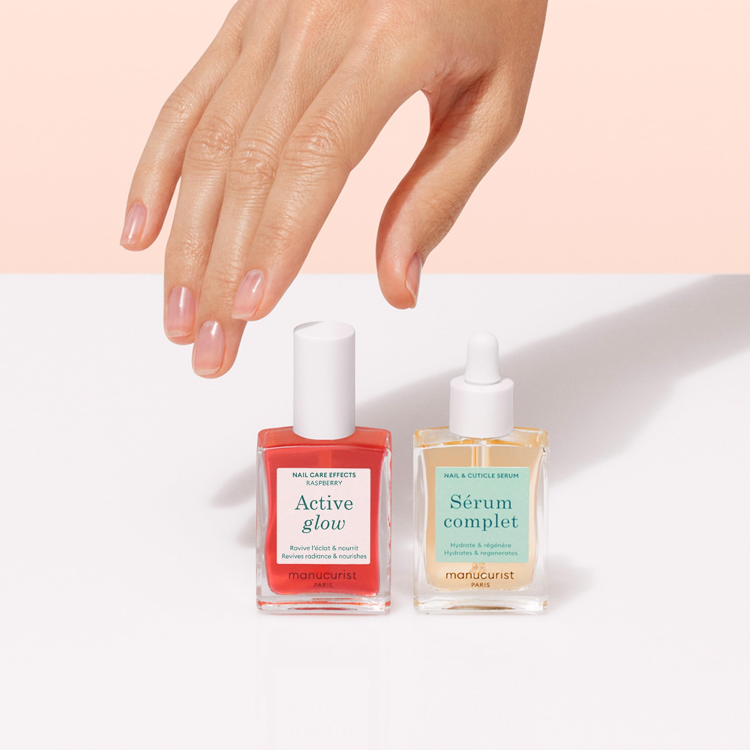 Pinceau appliquant le vernis rose framboise Manucurist, couleur homogène.