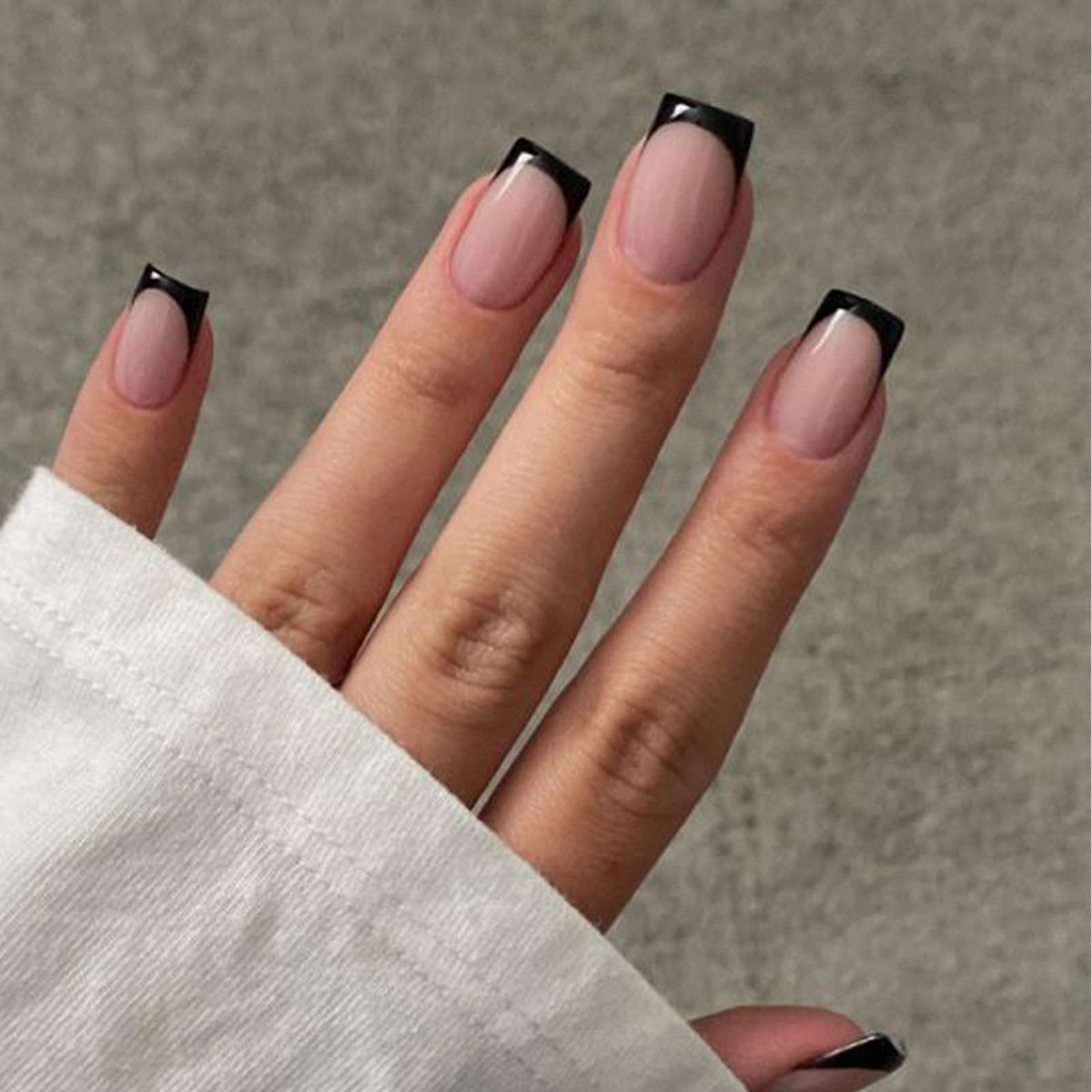 Modelones ongles noirs à bout français courts et carrés pour un look rapide.