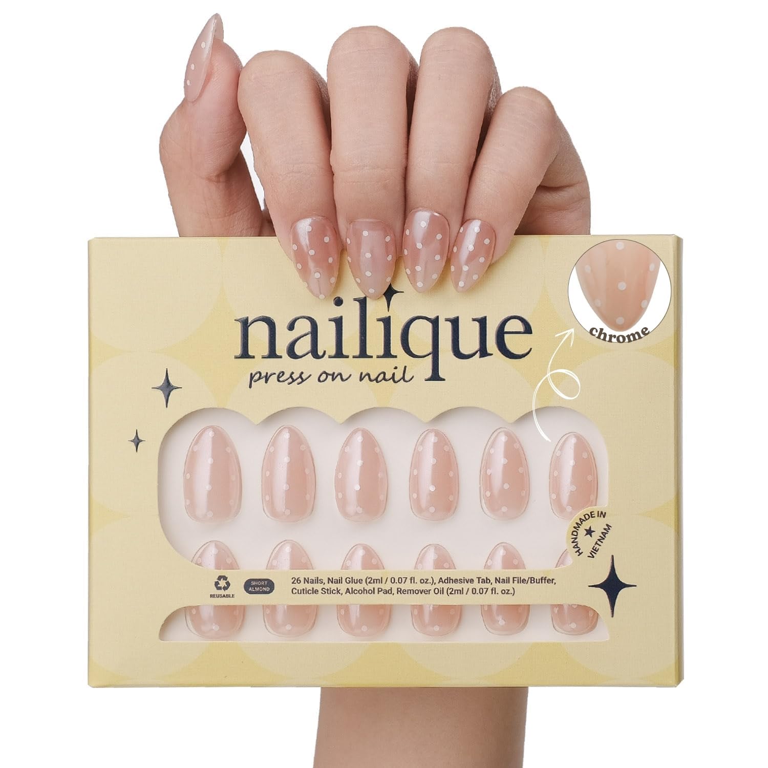 Nailique amande courte chrome nude avec points blancs, look chic.