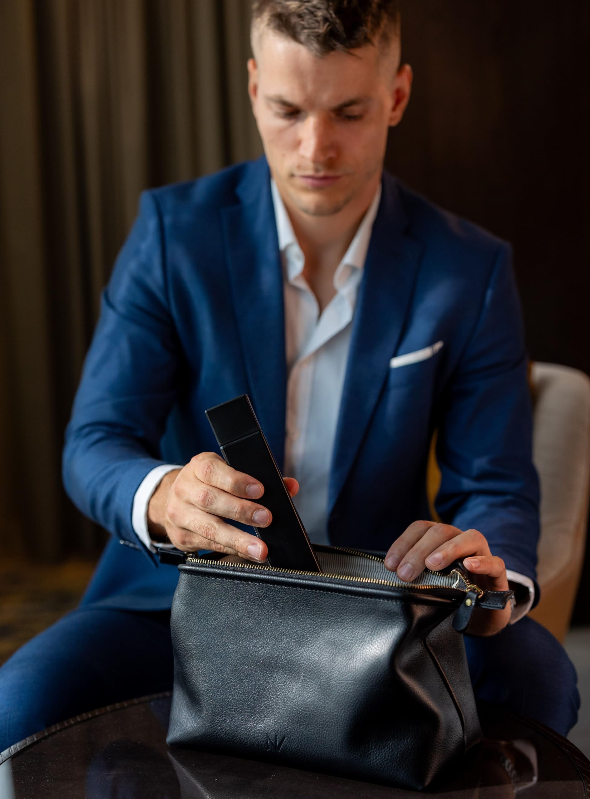 NV Holders trousse cuir noir avec anse métallique pour voyage.
