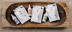 Ingrédients herbales visibles autour du flacon Oyin Handmade Juices et Berries.