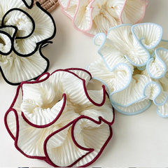 Chouchou Qigfucm blanc avec bordure rose, vue rapprochée montrant les plis.