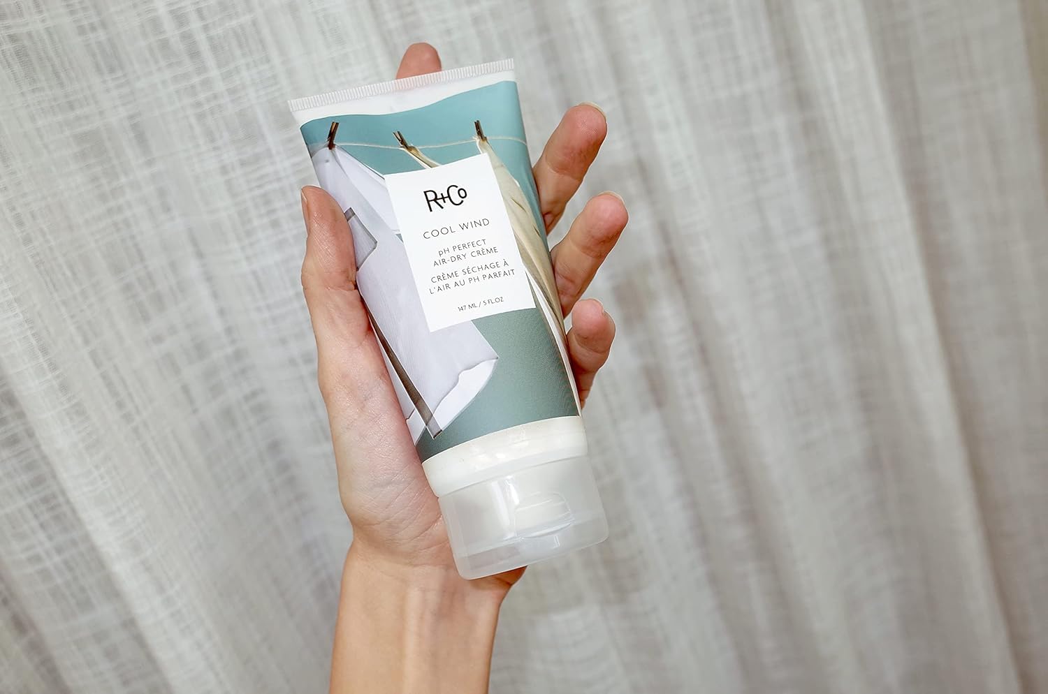 R+Co Cool Wind appliquer la crème sur cheveux pour coiffage facilité.