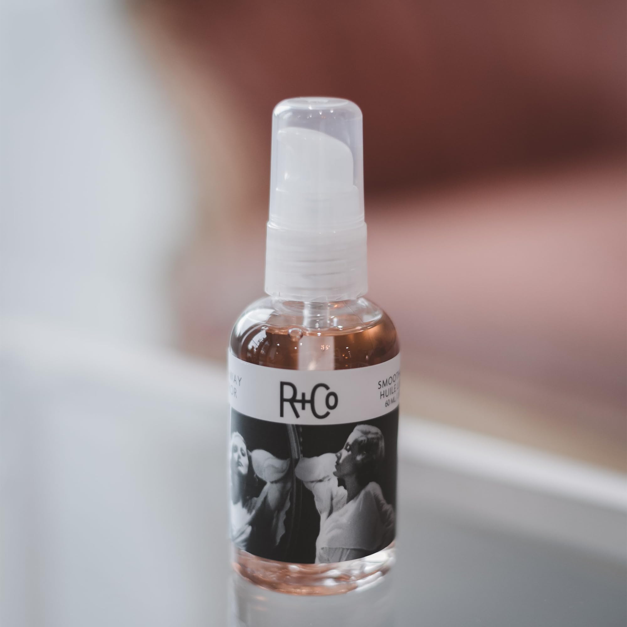 R+Co huile lissage miroir deux voies montre l'application, apporte douceur et brillance en quelques gestes.