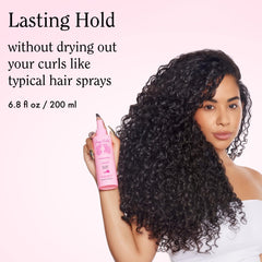 Rizos Curls spray mist dispersing on curly hair for bounce.