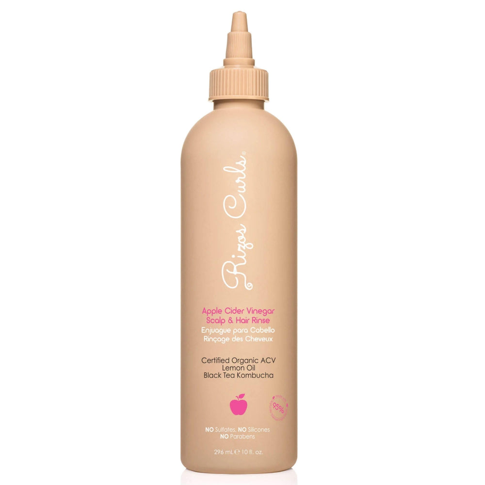Rizos Curls rinçage cidre versé depuis la bouteille pour clarifier les résidus.