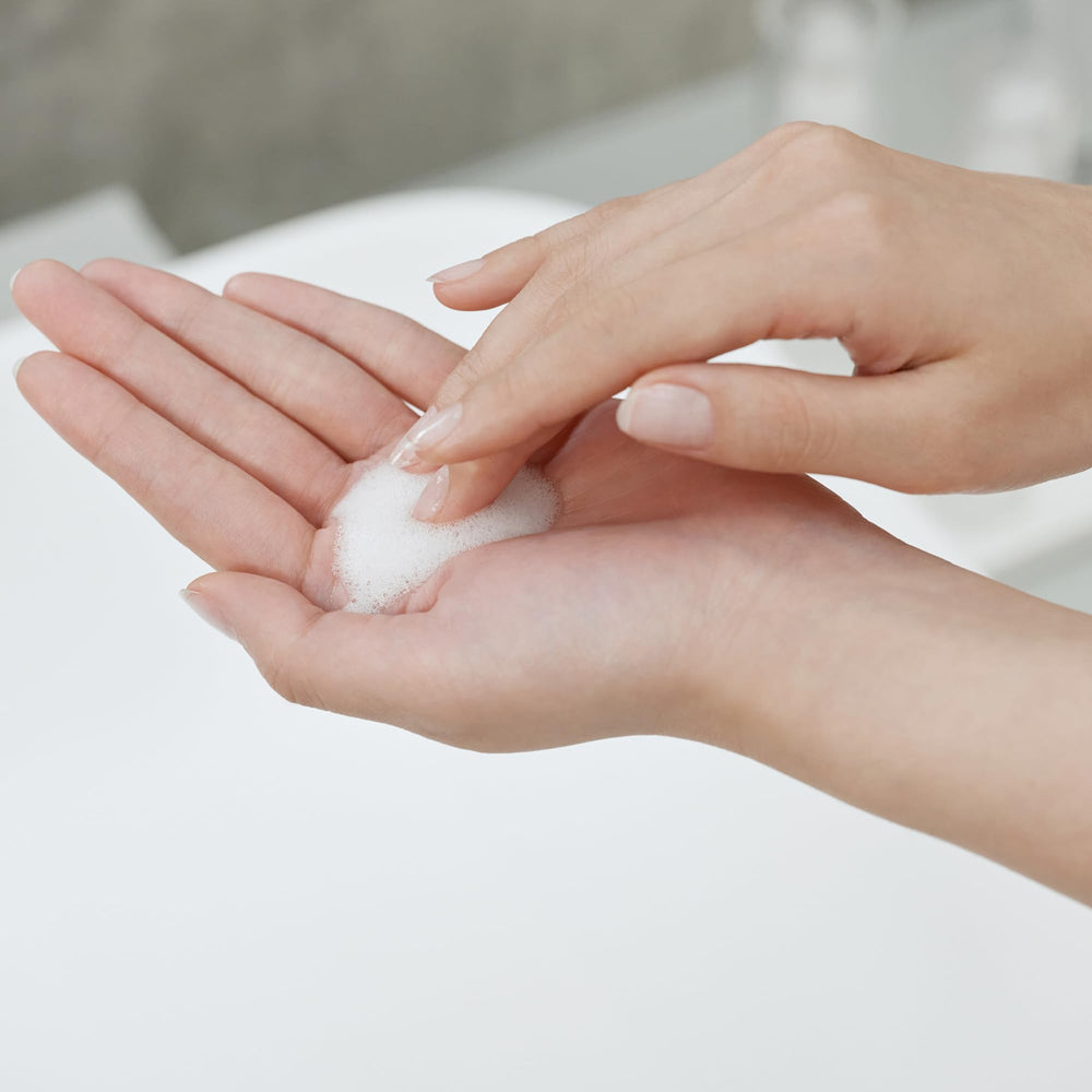 Application et massage sur le visage avec SK-II pour la douceur.