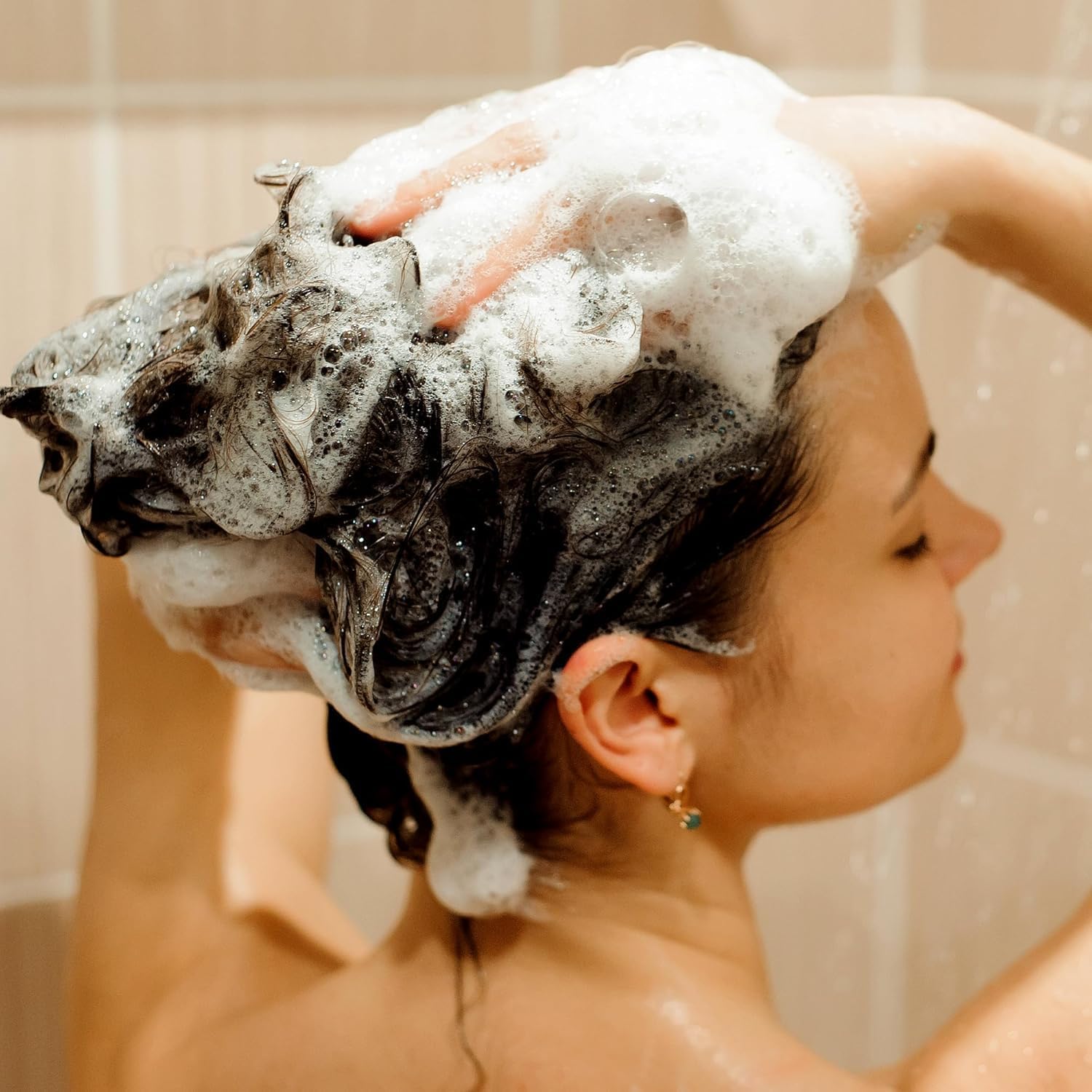Hands apply a small amount, illustrating easy distribution and gentle cleanse.