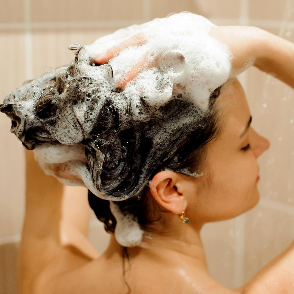 Hands apply a small amount, illustrating easy distribution and gentle cleanse.