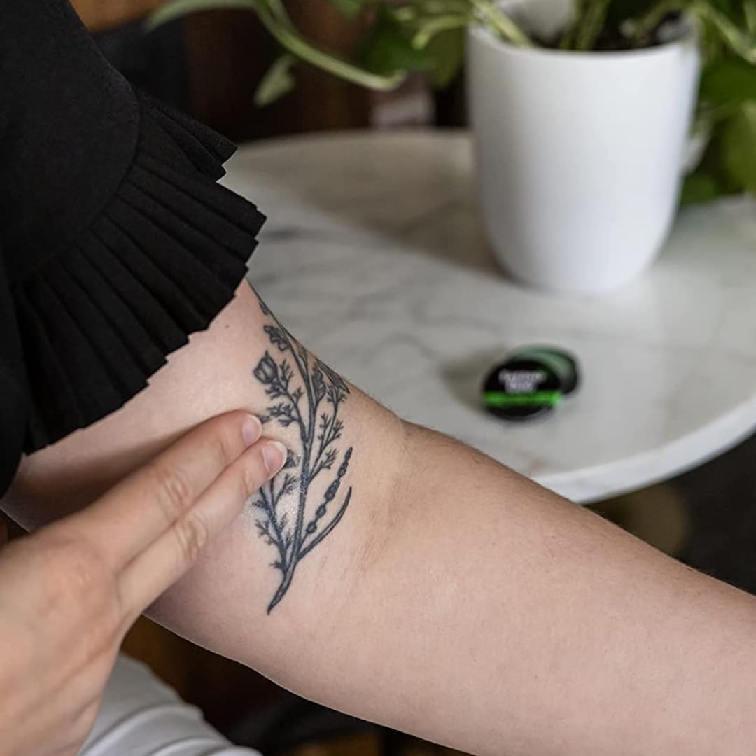 Texture crèmeuse de Tattoo Goo Original Balm sur la peau tatouée.