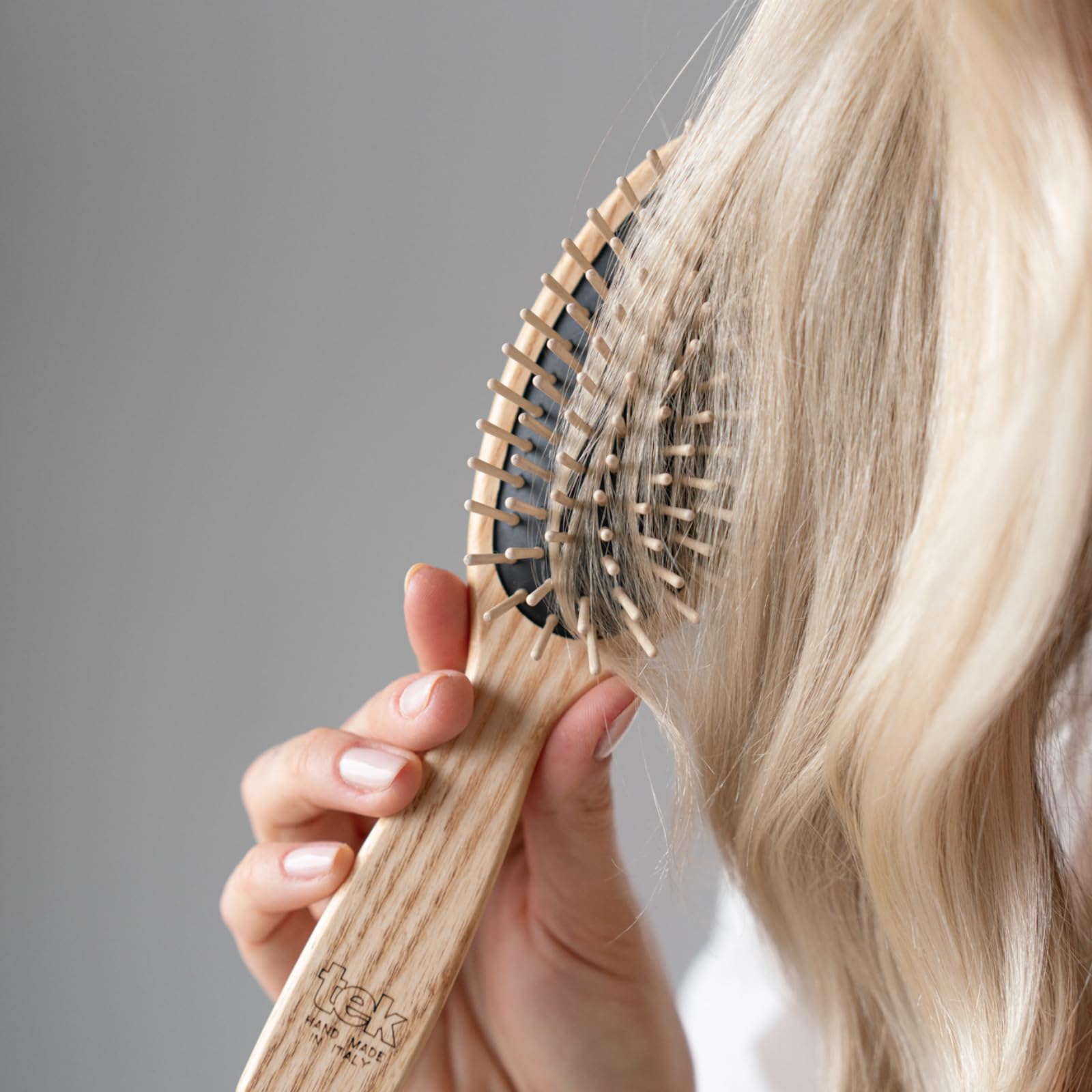 Brosse TEK oval avec dents courtes pour démêlage efficace.