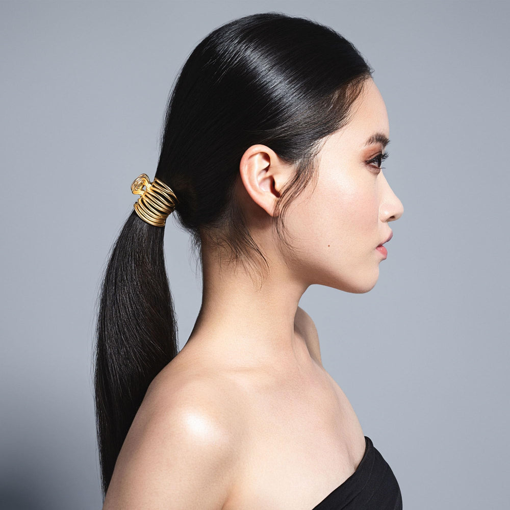 The Hair Edit agrippement doré enveloppant queue de cheval, design en fil léger.