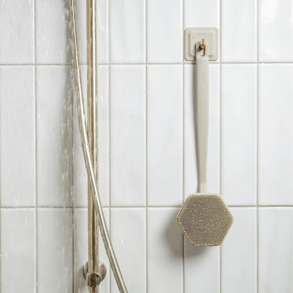 TOOLETRIES brosse-dos-silicone-rangement-compact, se range facilement dans la salle de bain.